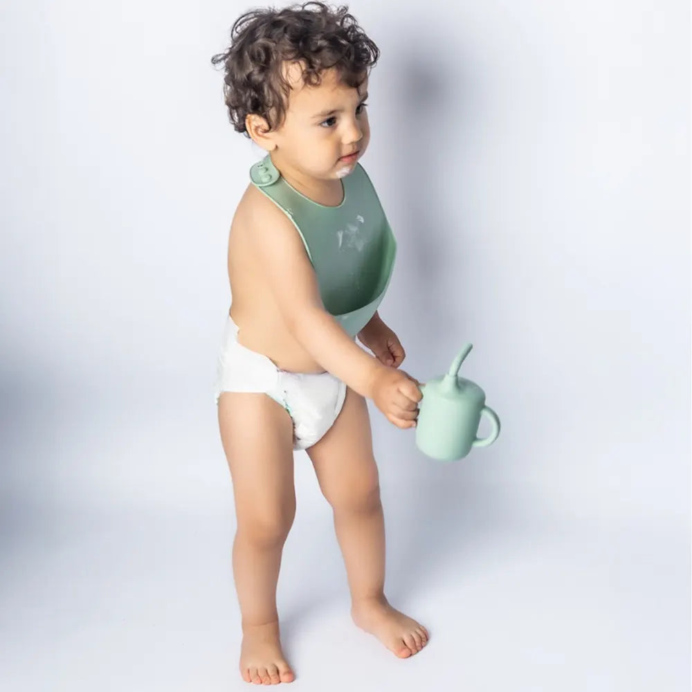 Bavoir YUMMY en silicone avec poche 4M+ porté par bébé – Nanou's House